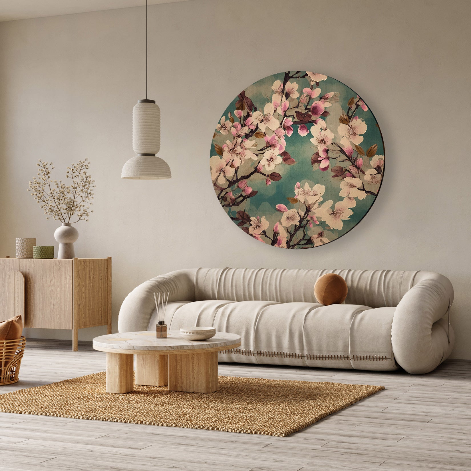 Ronde aluminium dibond muurcirkel met roze kersenbloesems op een blauwgroene achtergrond boven een beige bank.