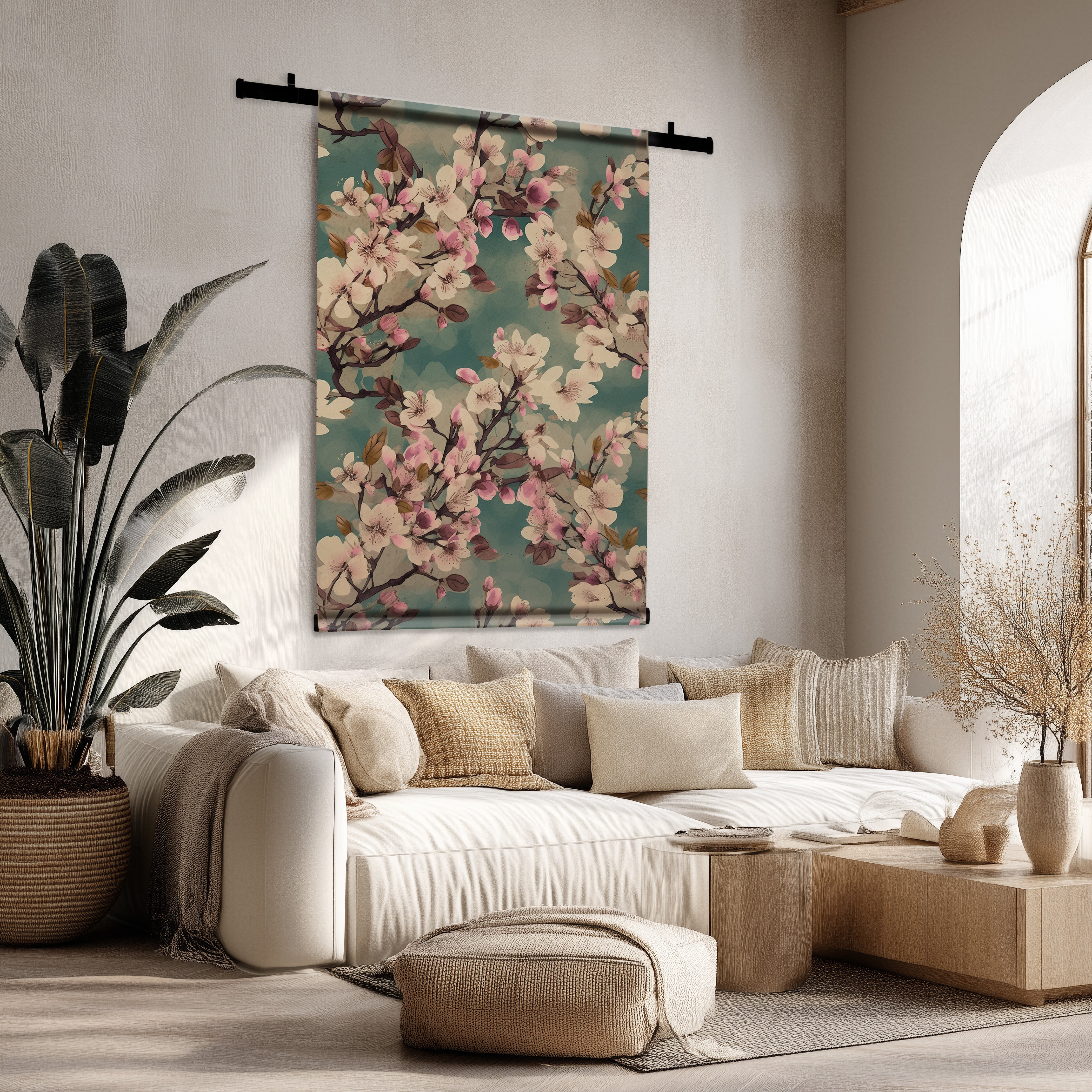 Kersenbloesem wandkleed met roze bloesems op een groenblauwe achtergrond, hangend boven een beige bank in een lichte woonkamer.
