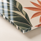 Materiaalvoorbeeld: Detail van plexiglas met botanische print, glanzend oppervlak en doorzichtige paneelrand.