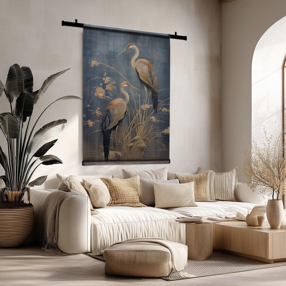 Wandkleed met Japanse kraanvogels op blauwe achtergrond, boven een beige bank in een modern interieur.